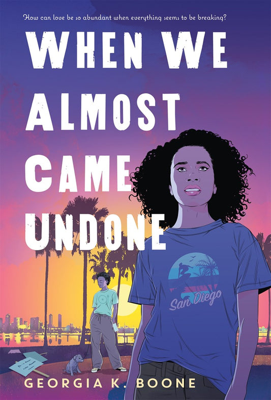 Book cover of 'When We Almost Came Undone' by Georgia K. Boone with a young Black woman with shoulder length hair and a San Diego tshirt against a purple sunset background